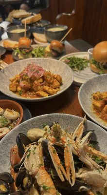 Sea food and burgers on plates in restaurant